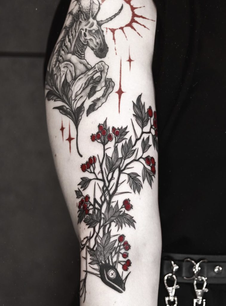Fantasietattoo met een gevleugeld wezen, bladeren en rode accenten, door Mara.