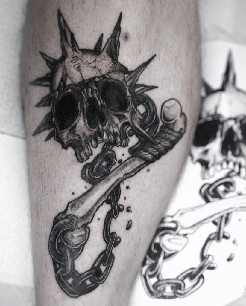 Dark-art-tattoo van een schedel met stekels en een ketting, door Sonja.