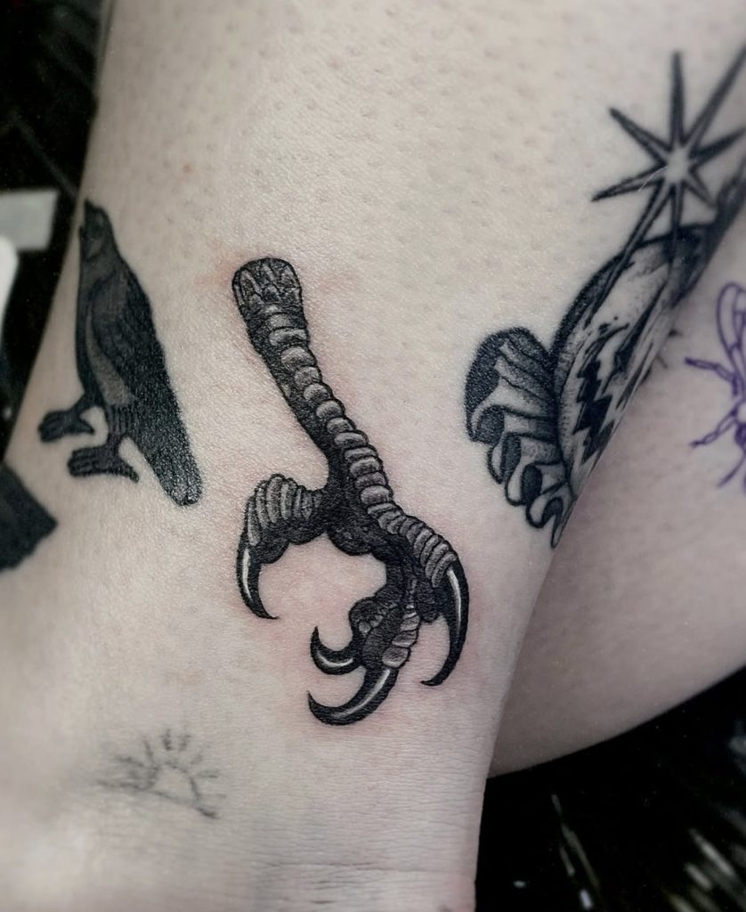 Gedetailleerde zwart-grijze tattoo van een vogelklauw, door Sonja.