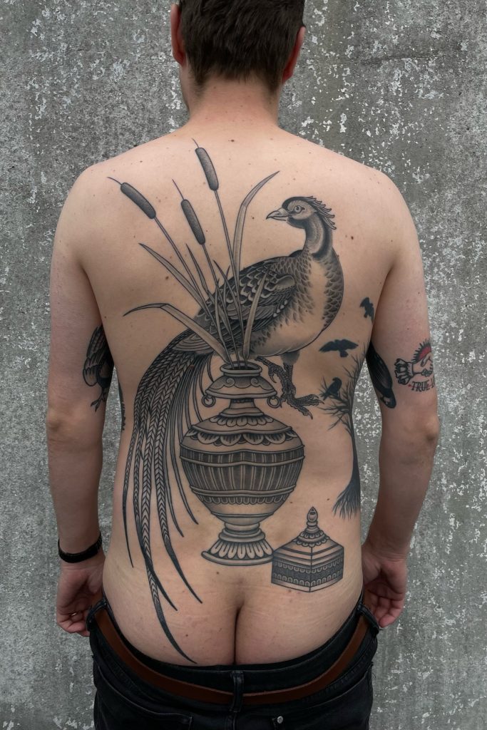 Backpiece of a bird and vase