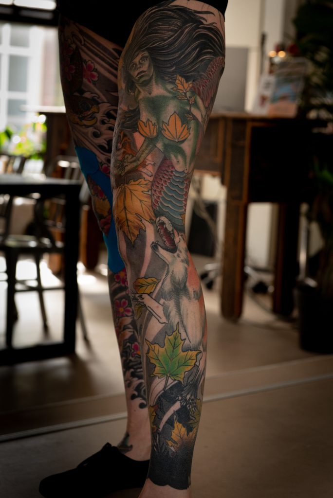 A mermaid, a wolf and autumn leaves on Lucie’s leg.